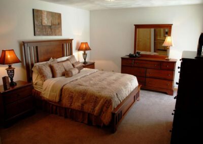 A cozy bedroom featuring a neatly made bed, a stylish dresser, and a bedside nightstand for convenience.