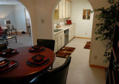 A dining room table elegantly set with four place settings, featuring plates, utensils, and glasses ready for a meal.