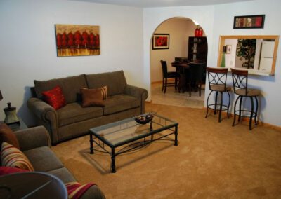 A cozy living room featuring a comfortable couch, a stylish coffee table, and a well-stocked bar area.